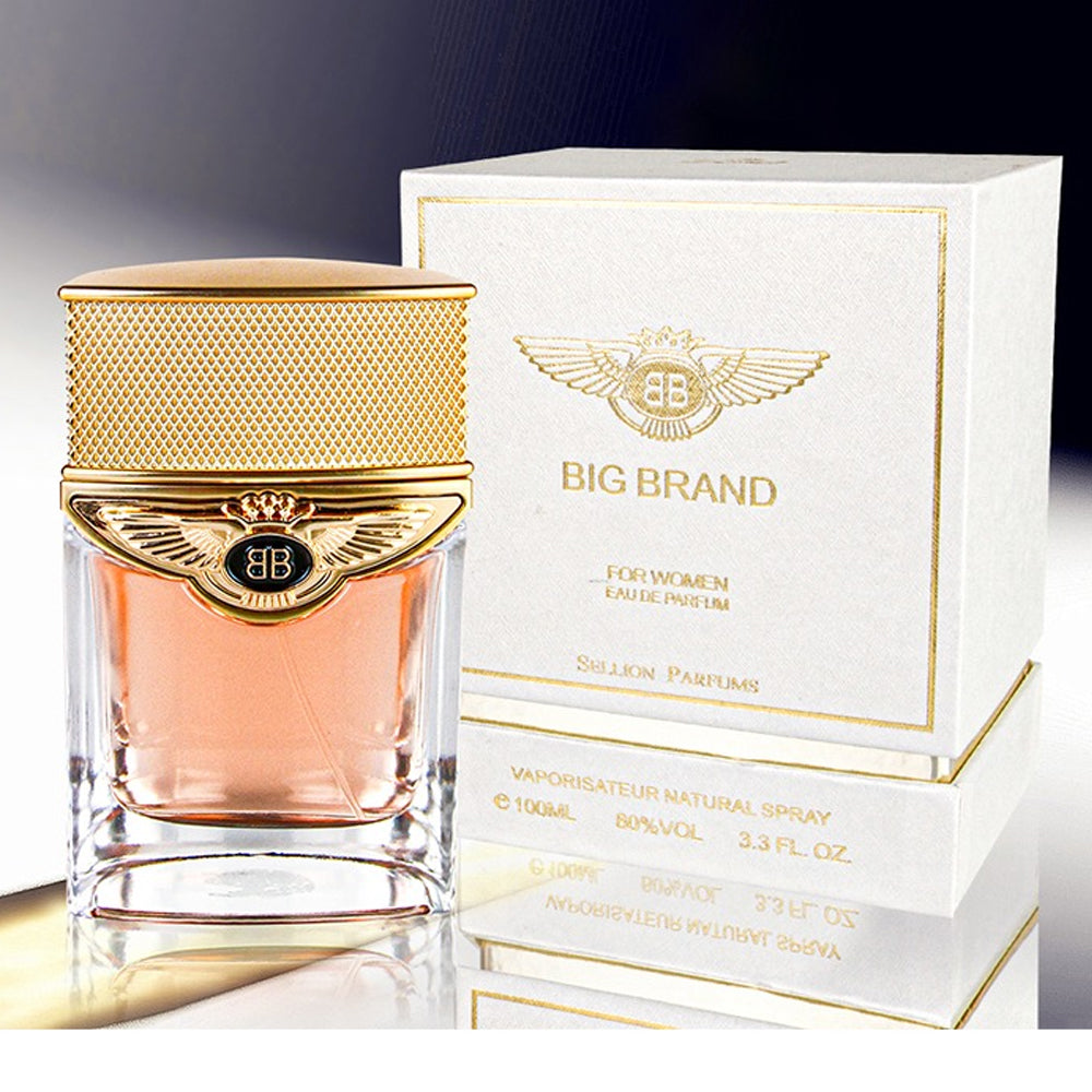Gold and clear perfume bottle with matching packaging on a gradient background